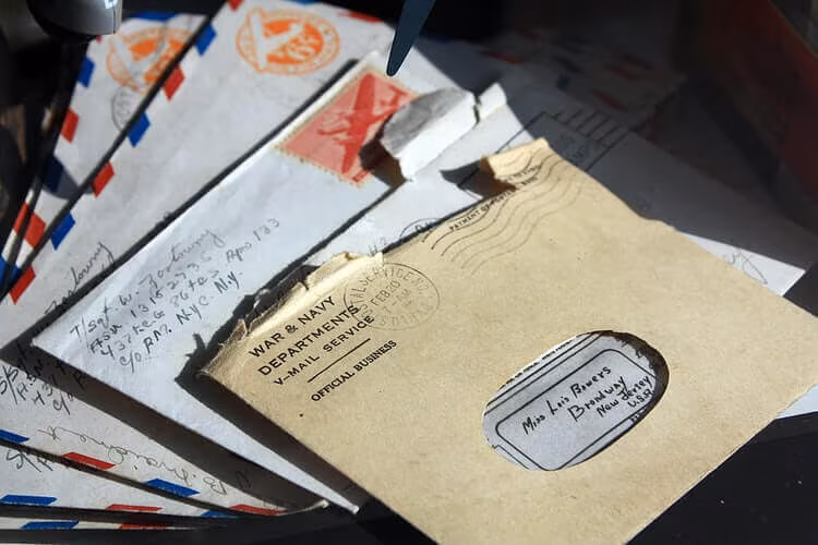 A pile of hand-addressed envelopes with postage stamps and postmarks