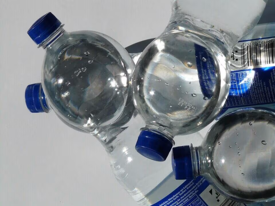 Clear plastic water bottles with blue caps