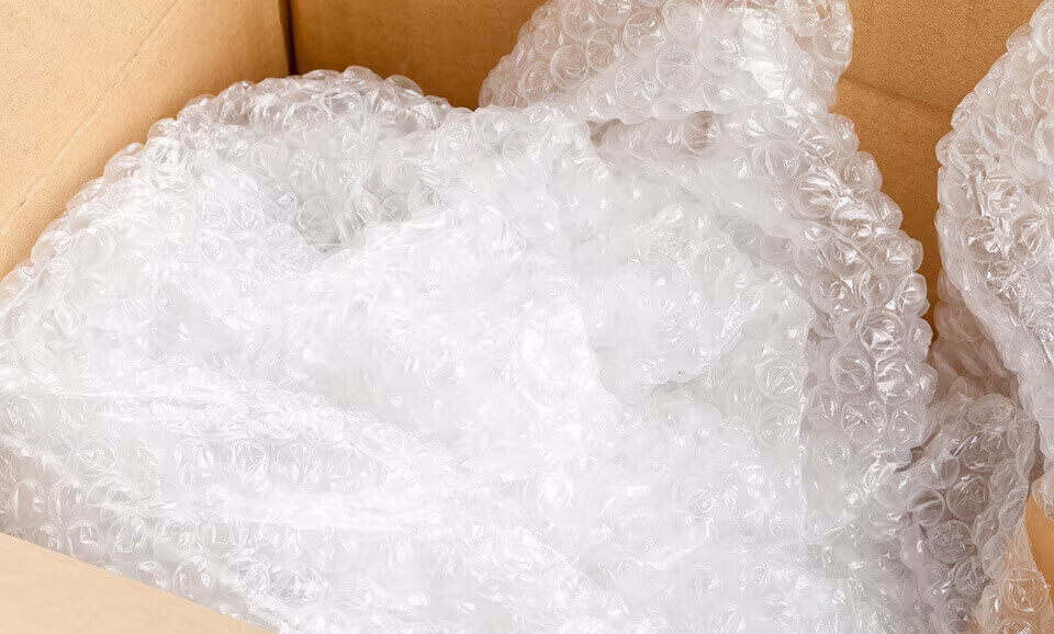 A crumpled sheet of bubble wrap in a cardboard box