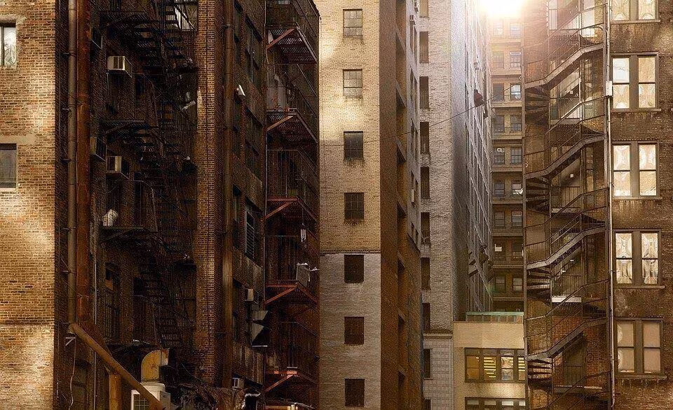 Tall brick apartment buildings with iron fire escapes