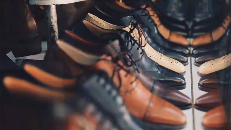 Rows of leather shoes lined up on a shelf