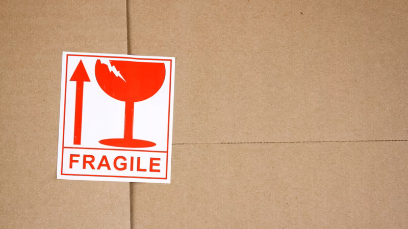 A red Fragile sticker with a broken-glass symbol on a cardboard box