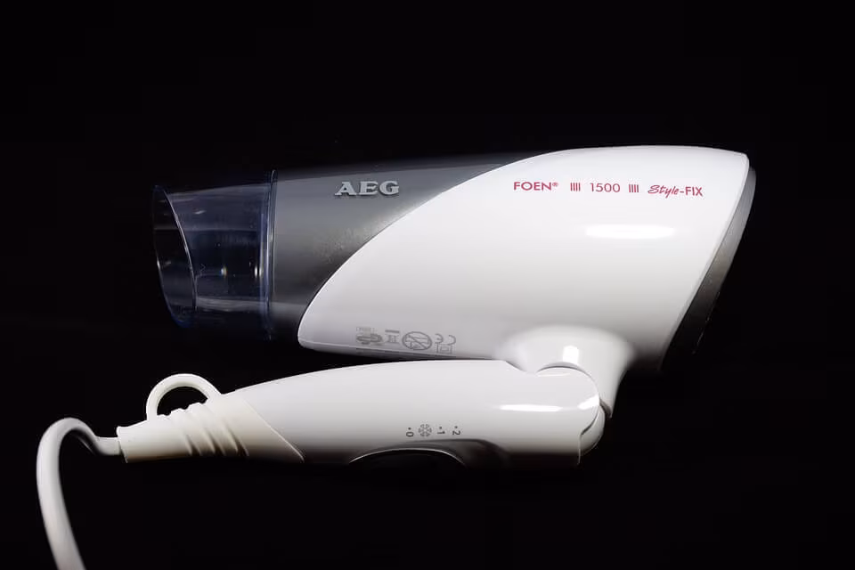 A white hairdryer against a black background