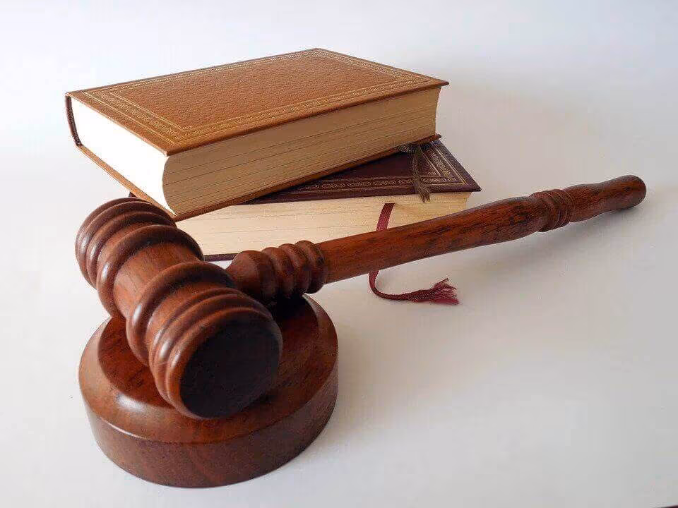 A wooden gavel resting against a closed book