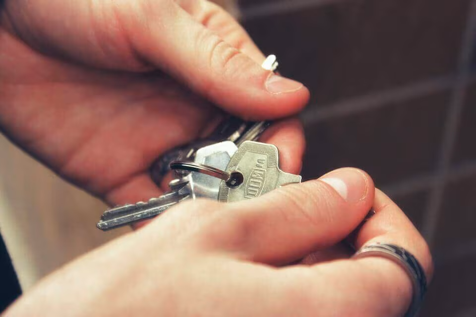 Close-up of one hand passing a set of keys to another