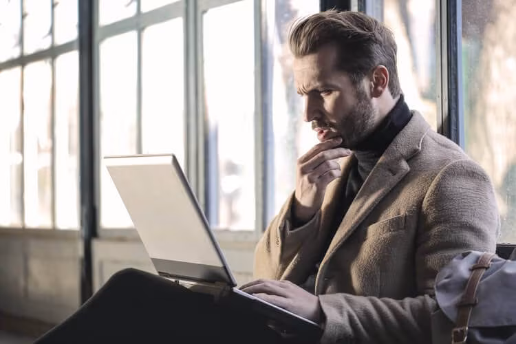 A man researching movers on a laptop