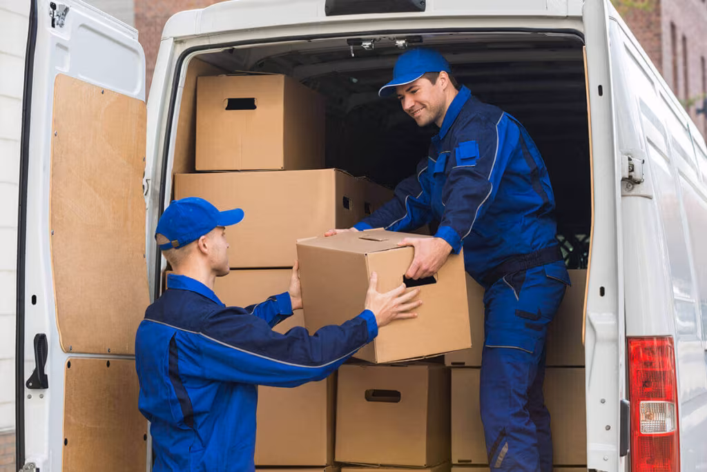 movers standing next to the pile of boxes unloading them