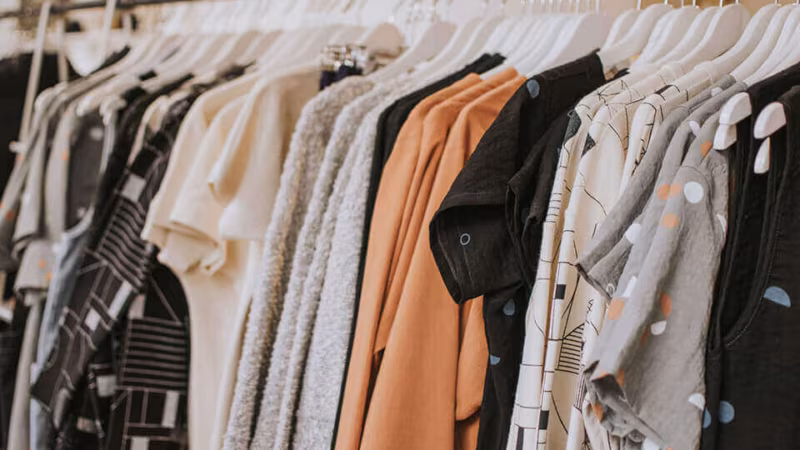 A crowded rail of clothes on hangers