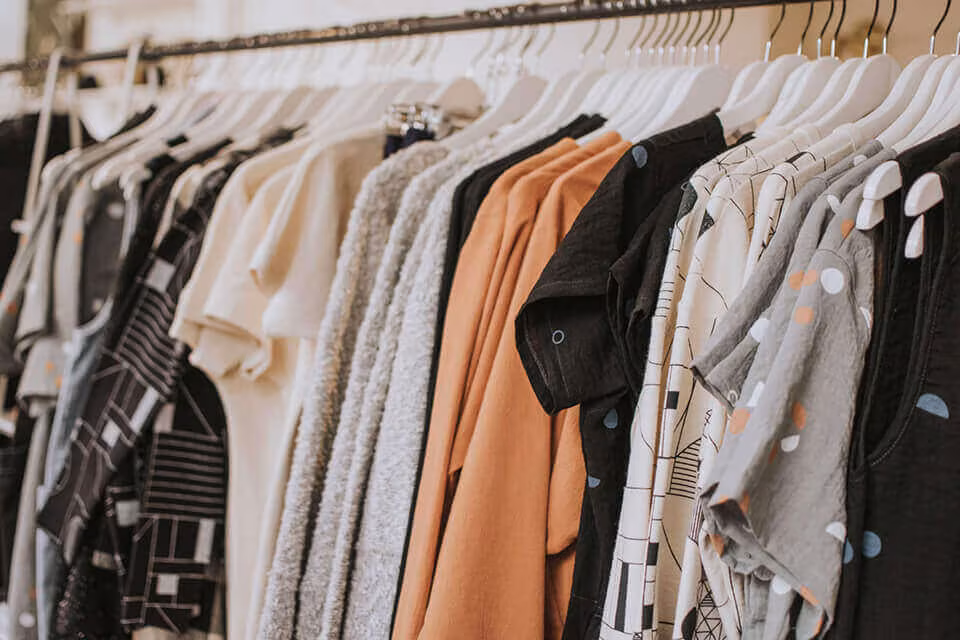 A crowded rail of clothes on hangers