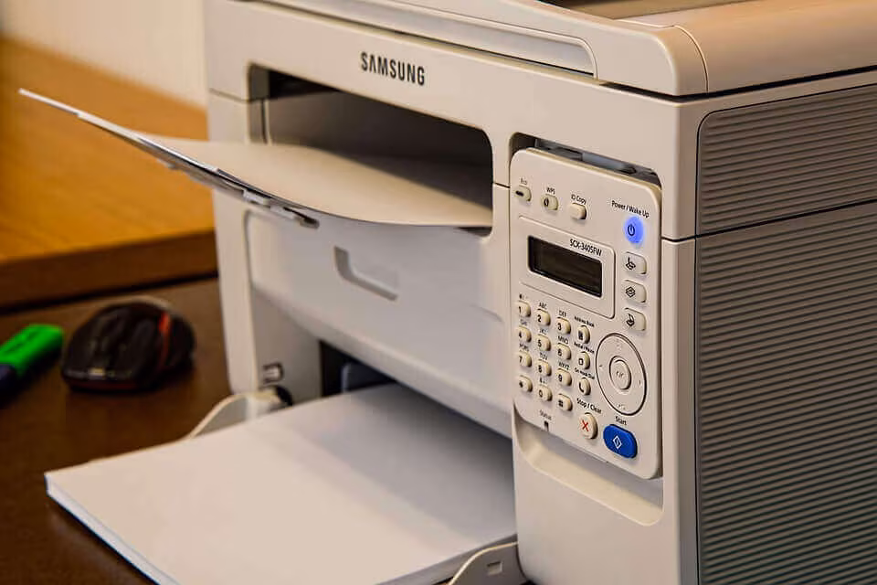 A desktop printer with a sheet of paper in the output tray