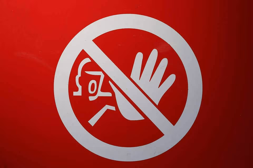 A red warning sign showing a raised hand refusing entry