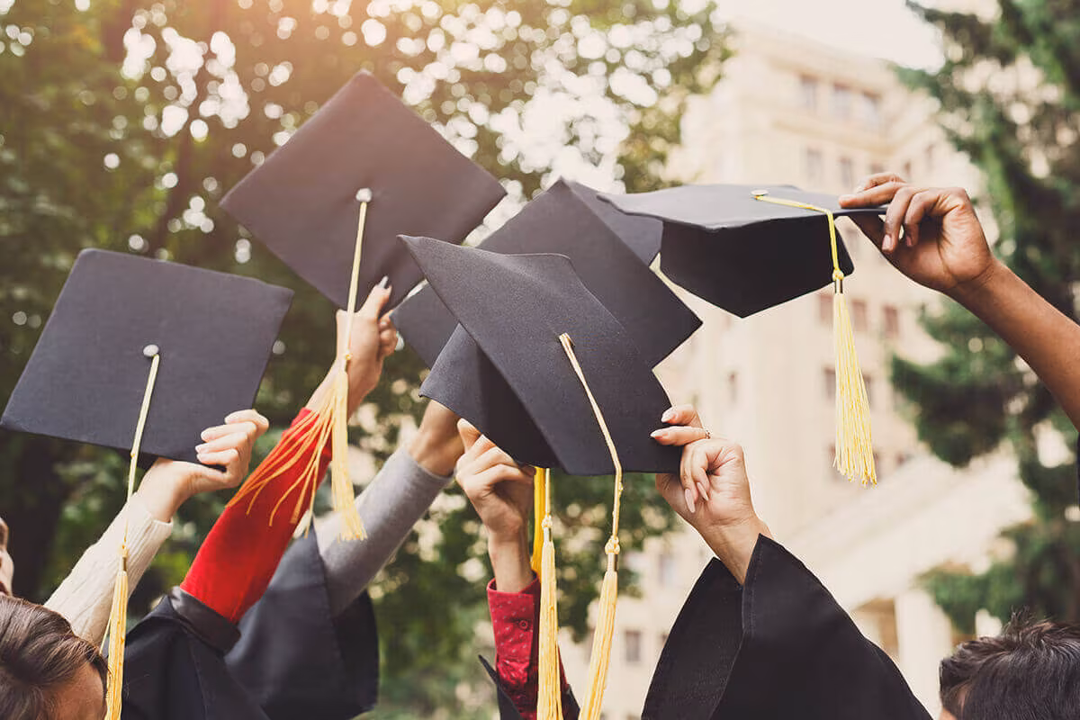 Graduates throwing their mortarboard caps in the air