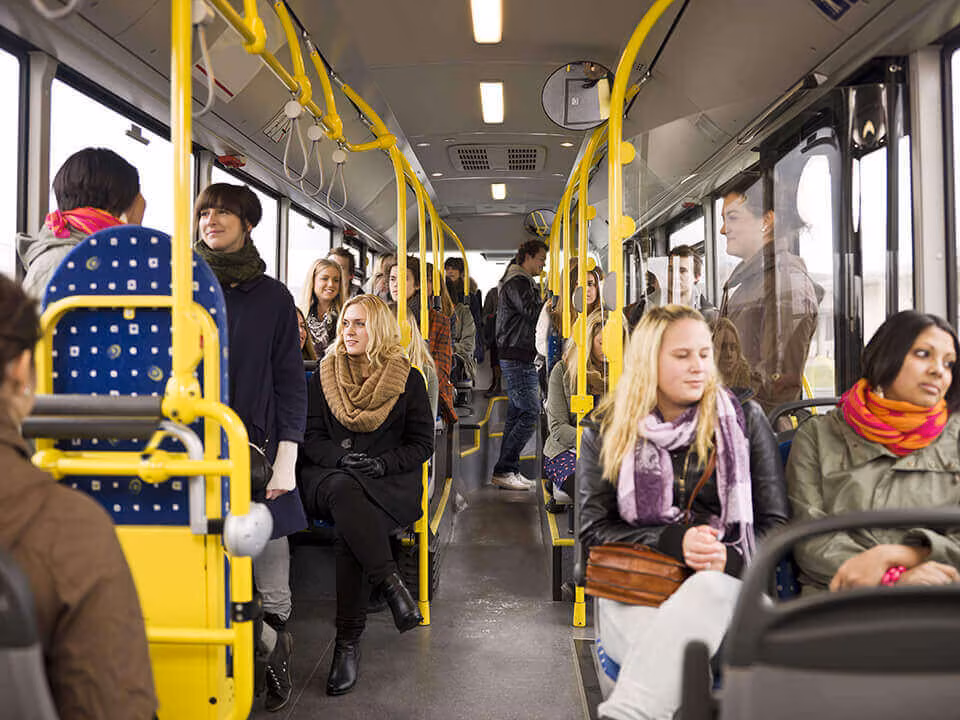 The interior of a bus with passengers standing and seated