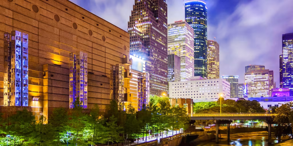 Panoramic view of the Houston skyline with tall modern skyscrapers under a clear sky.