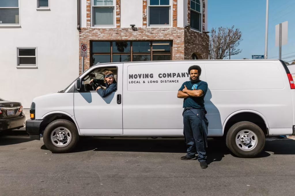 long-distance movers near a moving truck, smiling