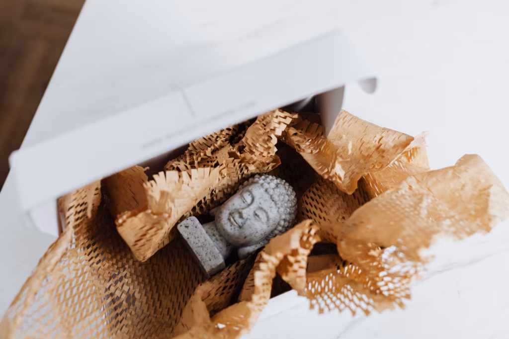 a packed Buddha statue in some packing paper, ready for moving across the country