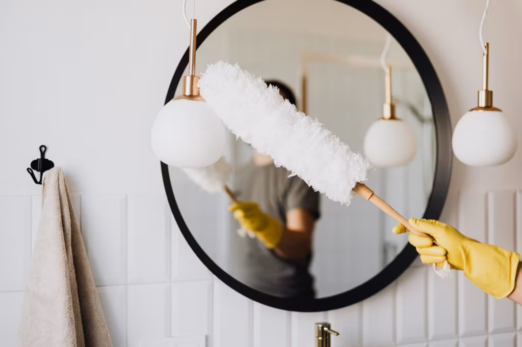 Wiping a mirror with a dustpan