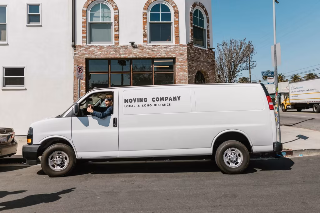 White minivan labeled with a local and long-distance moving company