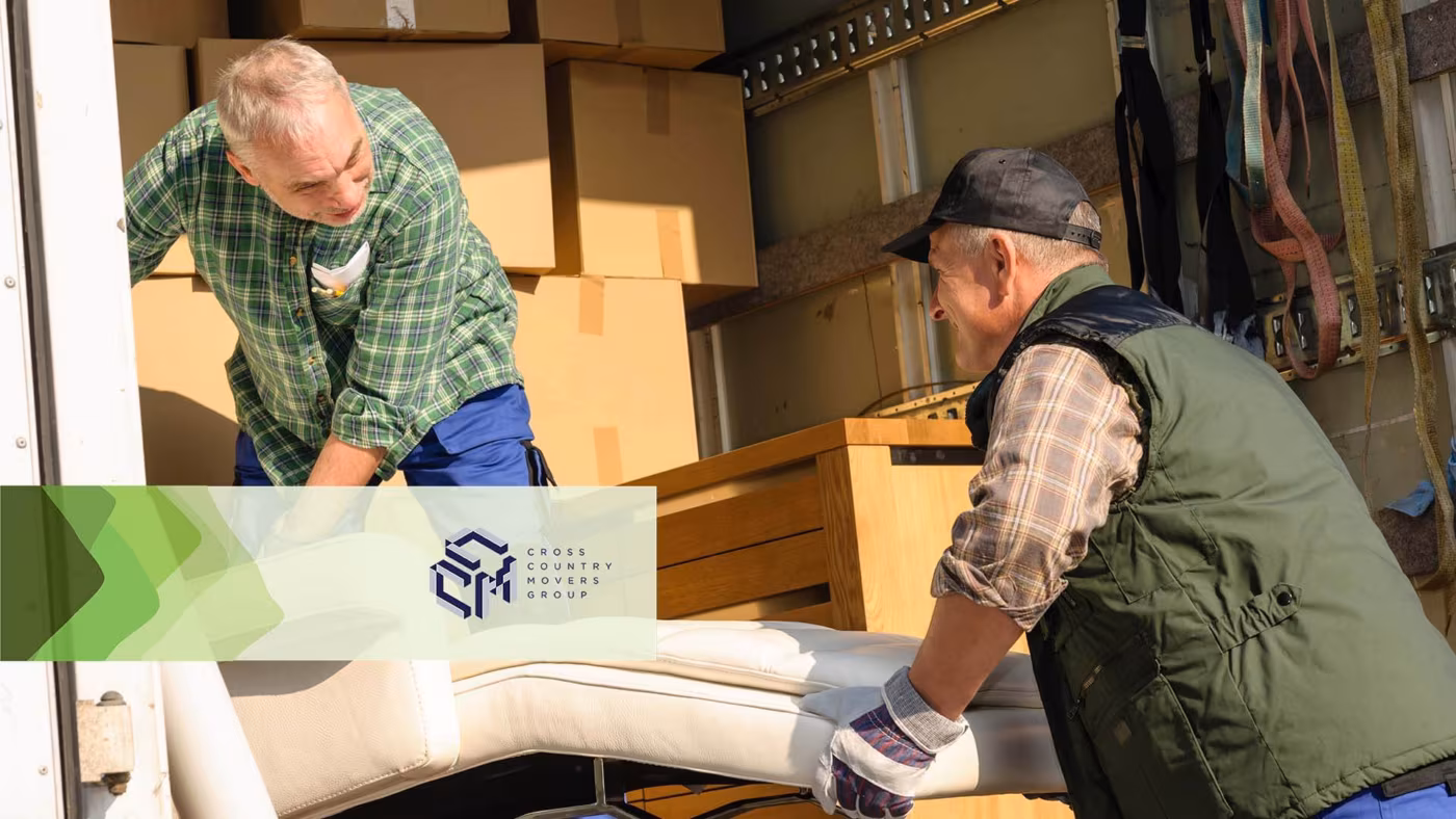 Two men loading furniture into the back of a moving truck