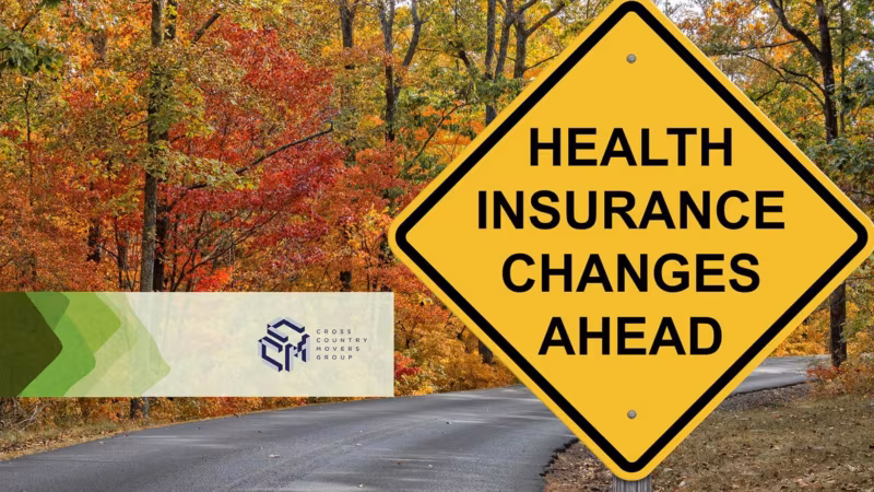A yellow road sign reading Health insurance changes ahead beside an autumn road