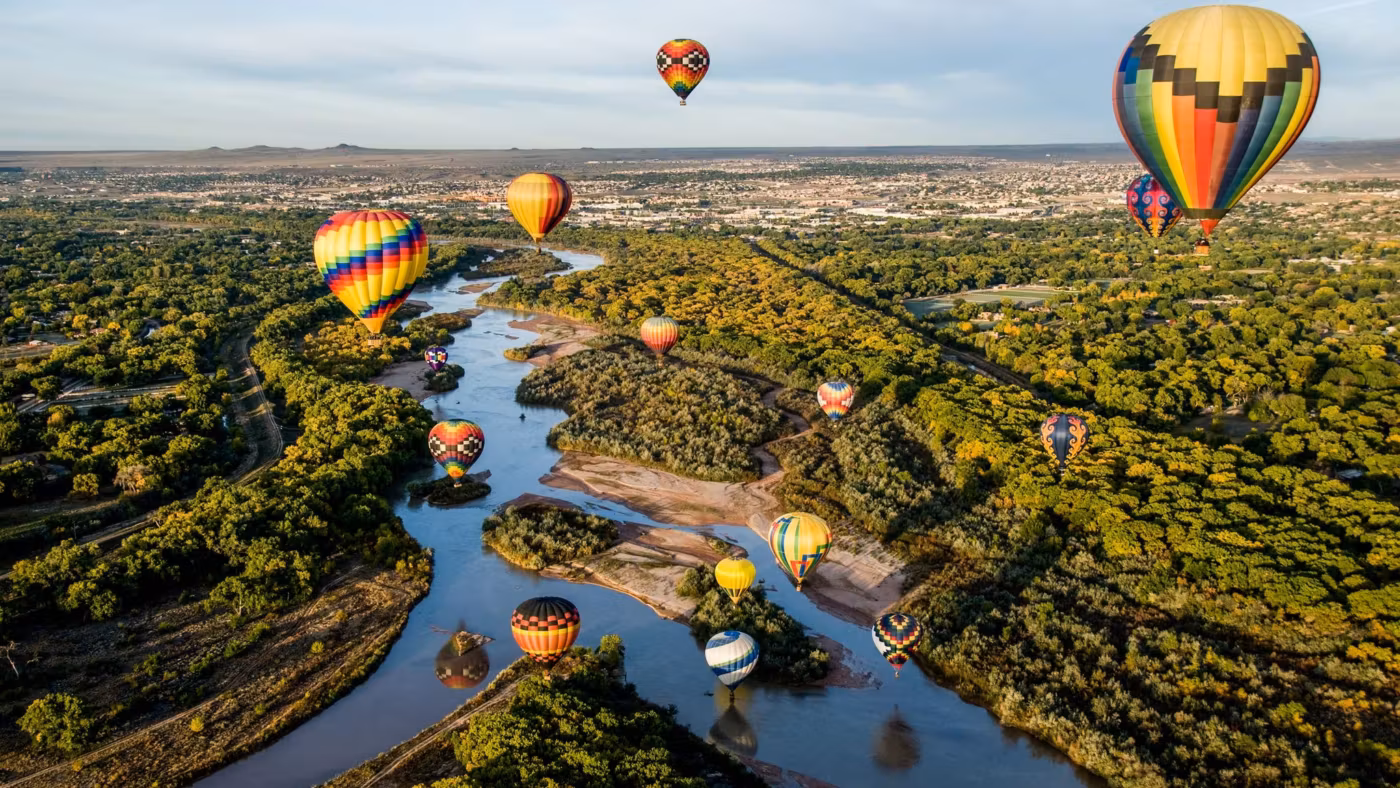 Hot-air balloons over the Rio Grande and the cottonwoods at Albuquerque