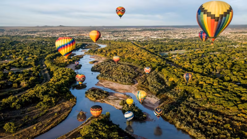 Hot-air balloons over the Rio Grande and the cottonwoods at Albuquerque