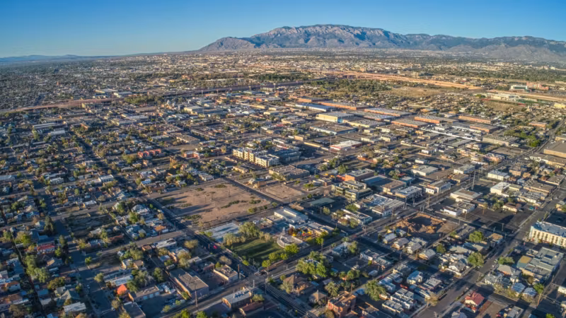 Aerial view of Albuquerque's residential street grid with the Sandia Mountains behind