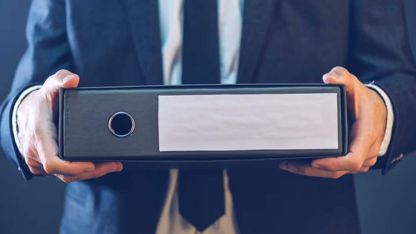 A pair of hands holding an open ring binder