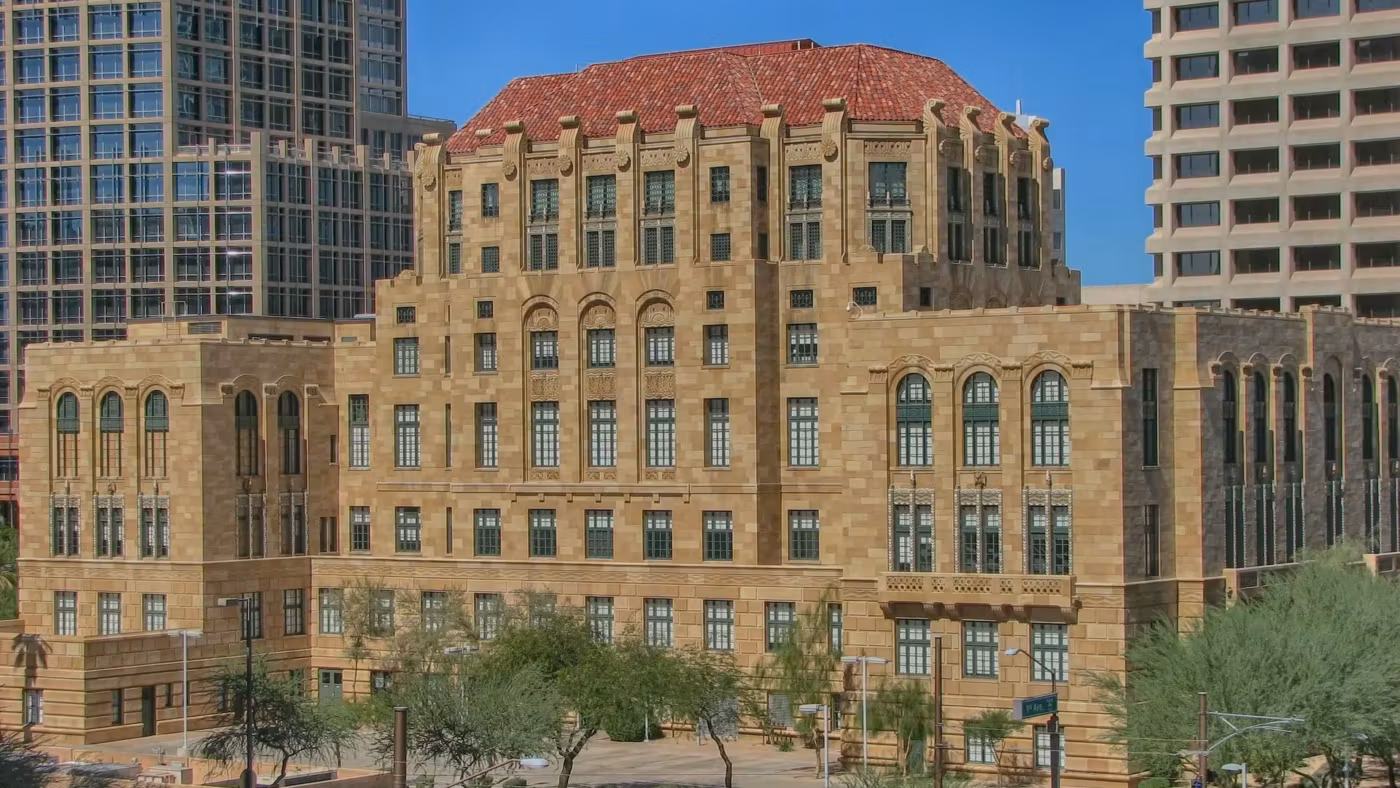 A tiled-roof historic courthouse in Phoenix among the modern towers