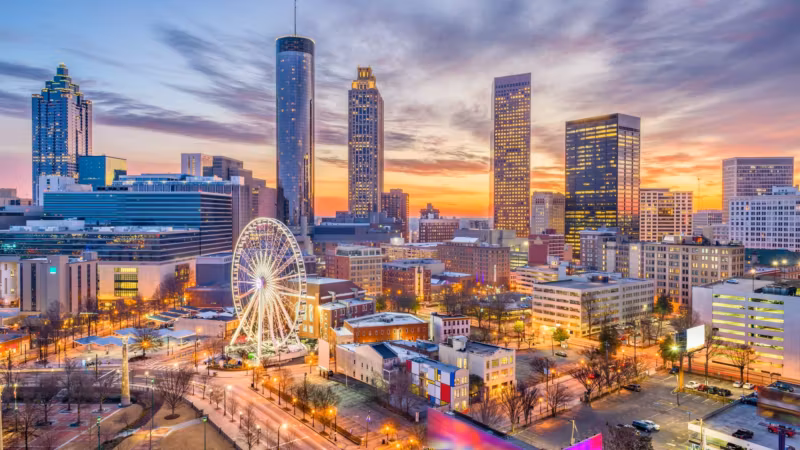 The Atlanta skyline at sunset with the ferris wheel lit below it