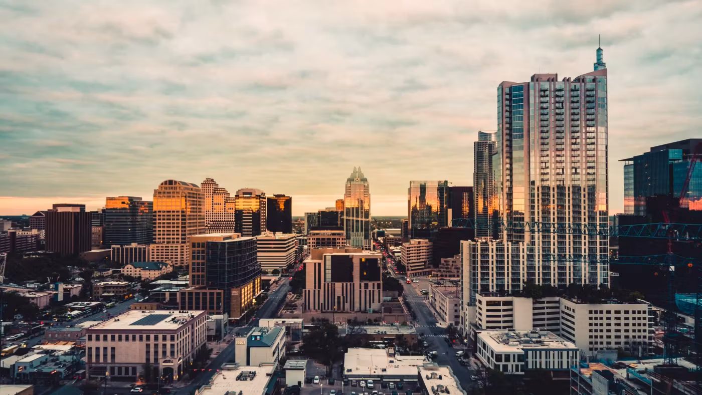 Downtown Austin from above at dusk, mid-rise blocks and the streets between them