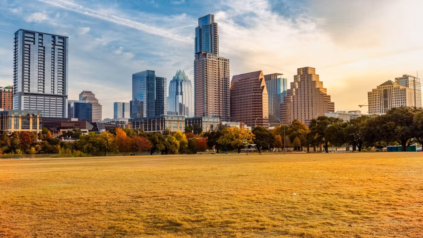 The Austin skyline seen across a wide park lawn in autumn