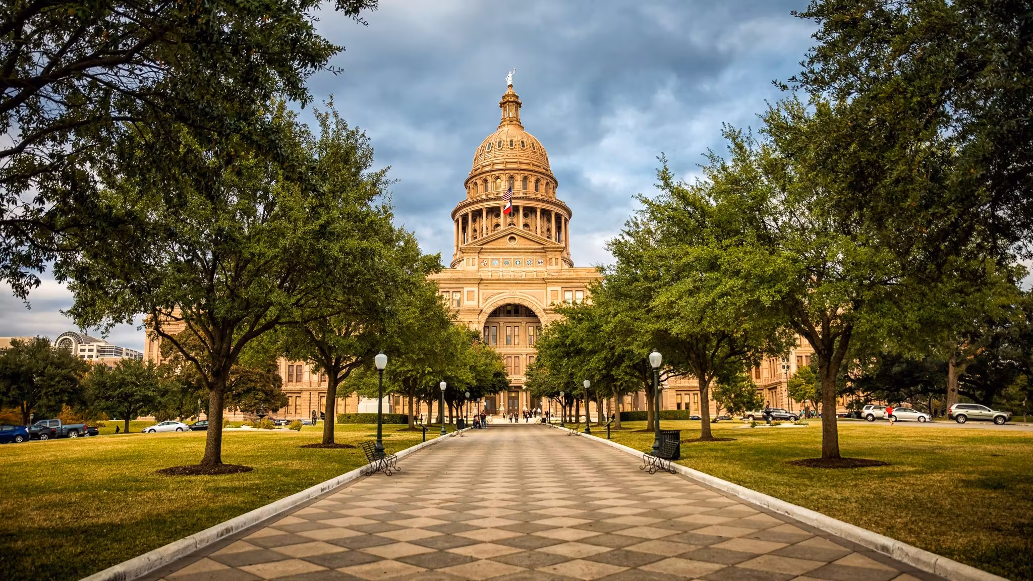 The Texas Capitol seen along its tree-lined walk in Austin