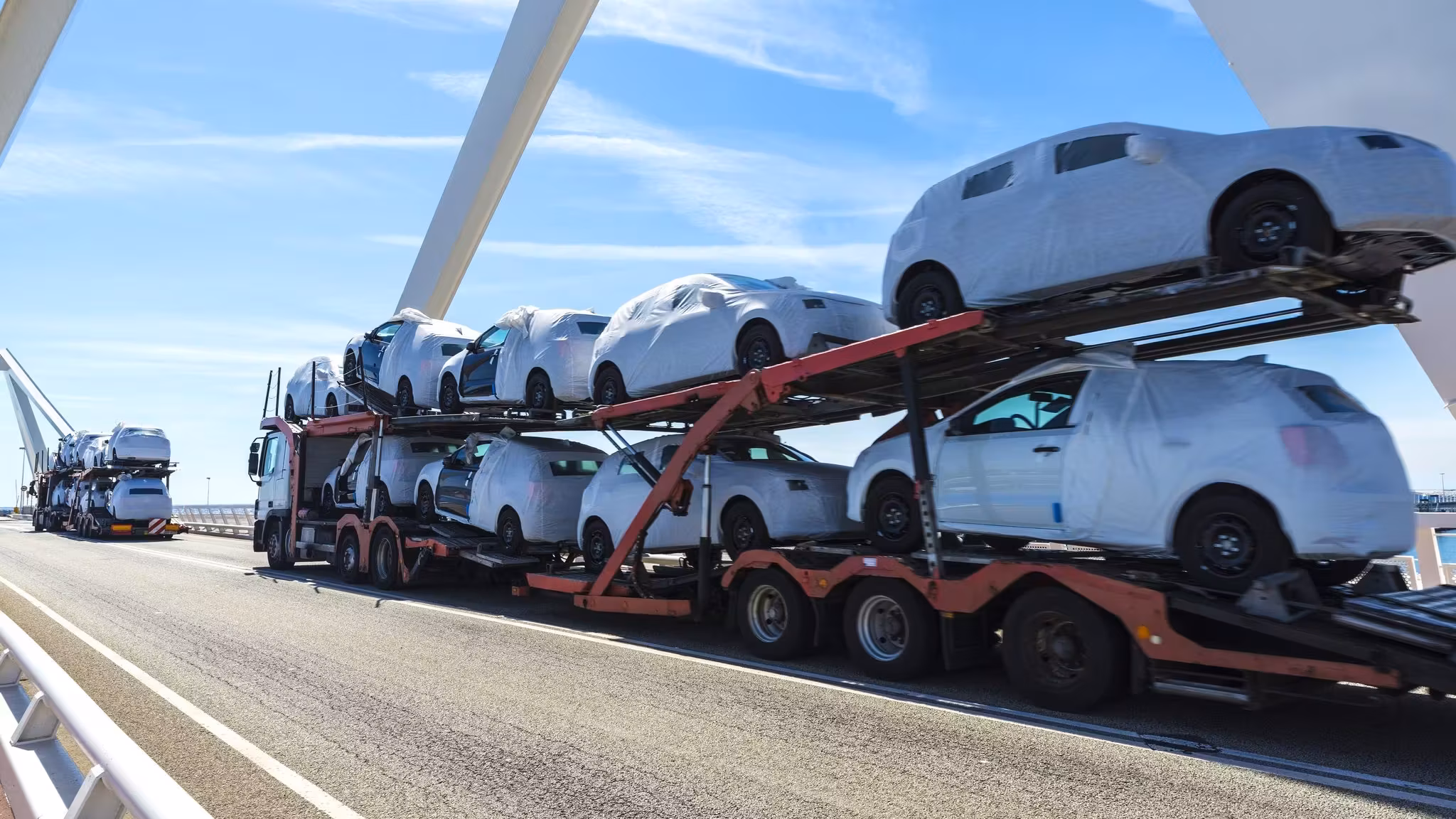A loaded car carrier on a highway, vehicles stacked on its upper and lower decks