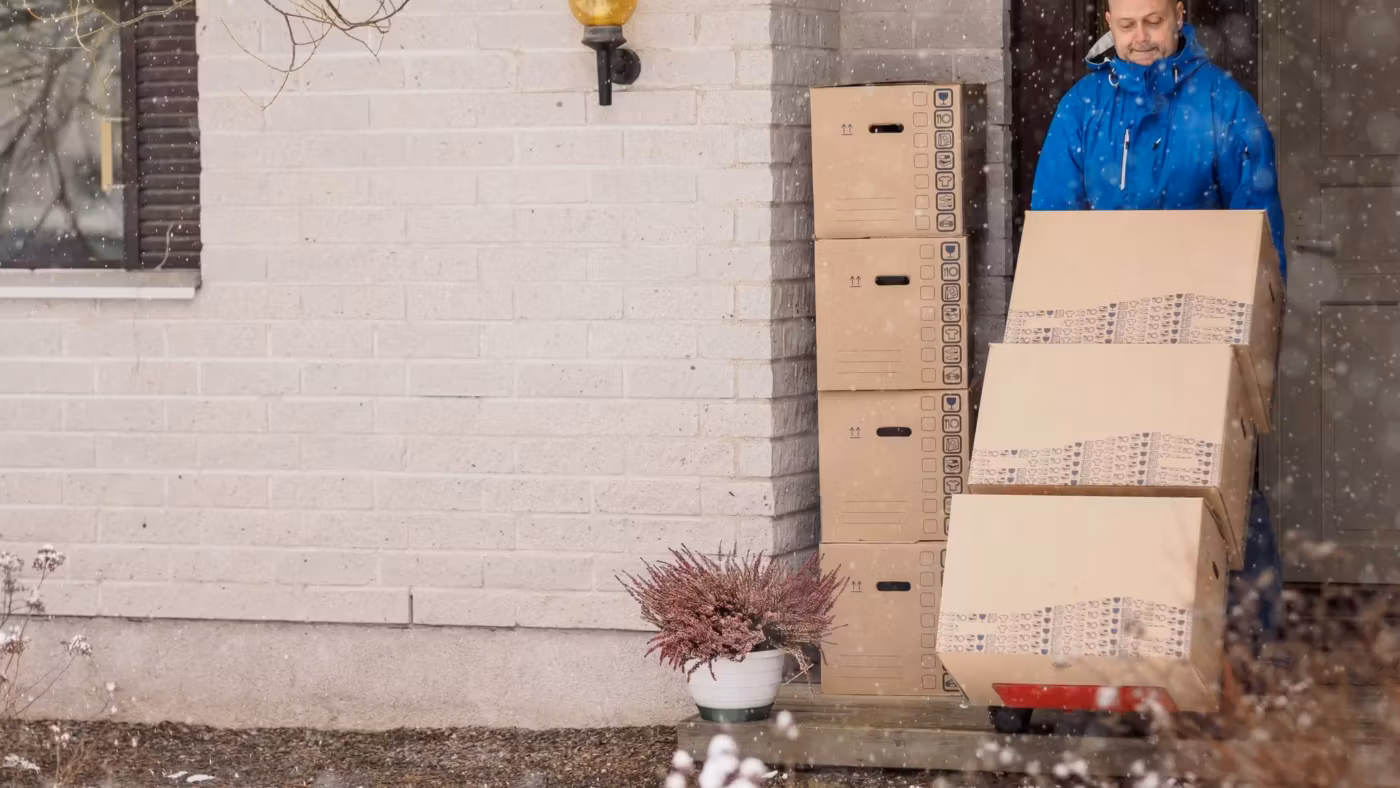Cartons stacked in an open doorway with bare ground outside