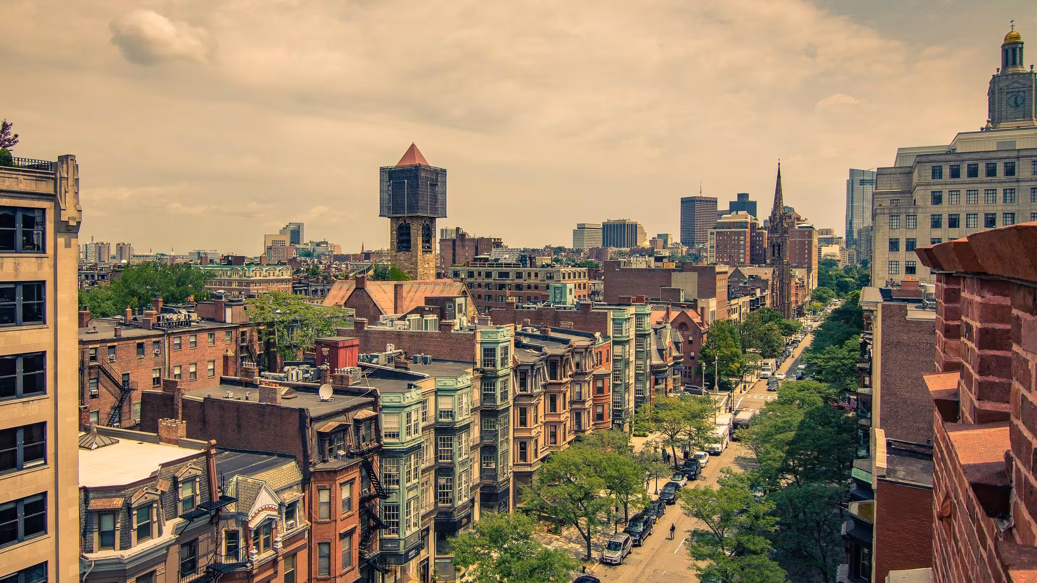 Rooftops and brick streets of Boston's Back Bay running down to the river