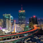 The Zakim Bridge and elevated highway into Boston, traffic drawn out in light trails at dusk