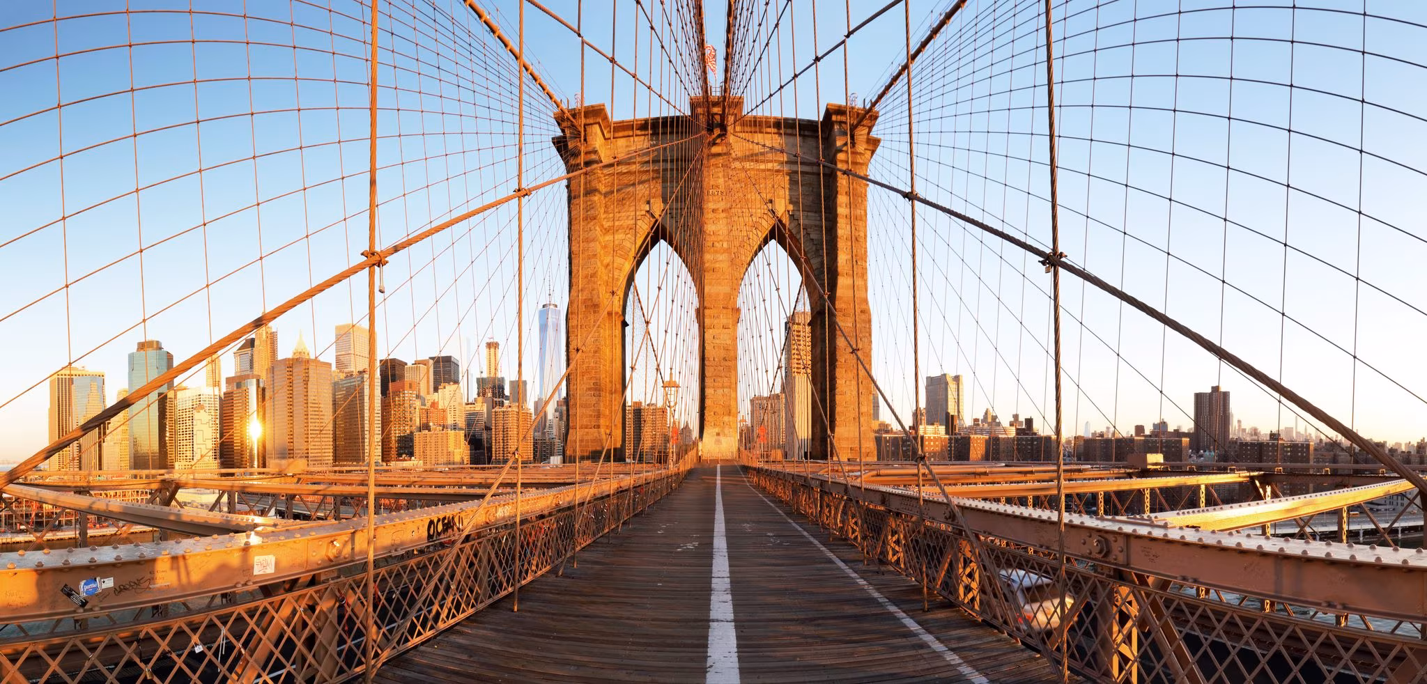 The wooden walkway of the Brooklyn Bridge running through one of its stone towers