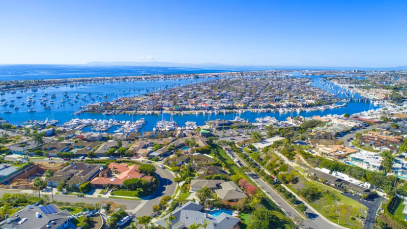 Aerial view of a California coastal neighborhood, houses and moored boats along the water