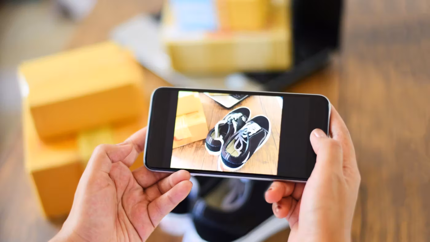 Hands photographing an object on a phone screen