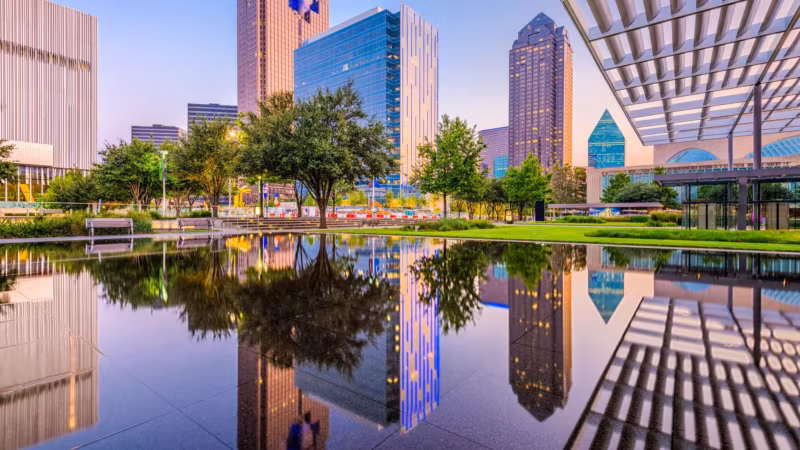 Downtown Dallas towers reflected in a still park pool