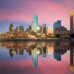 The Dallas skyline reflected in still water at dusk with Reunion Tower at the right