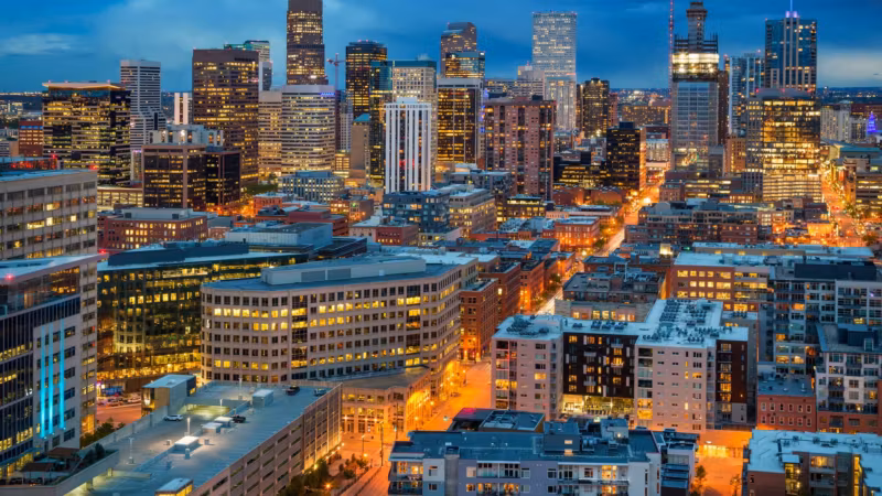 Downtown Denver at night, lit towers standing above the streets