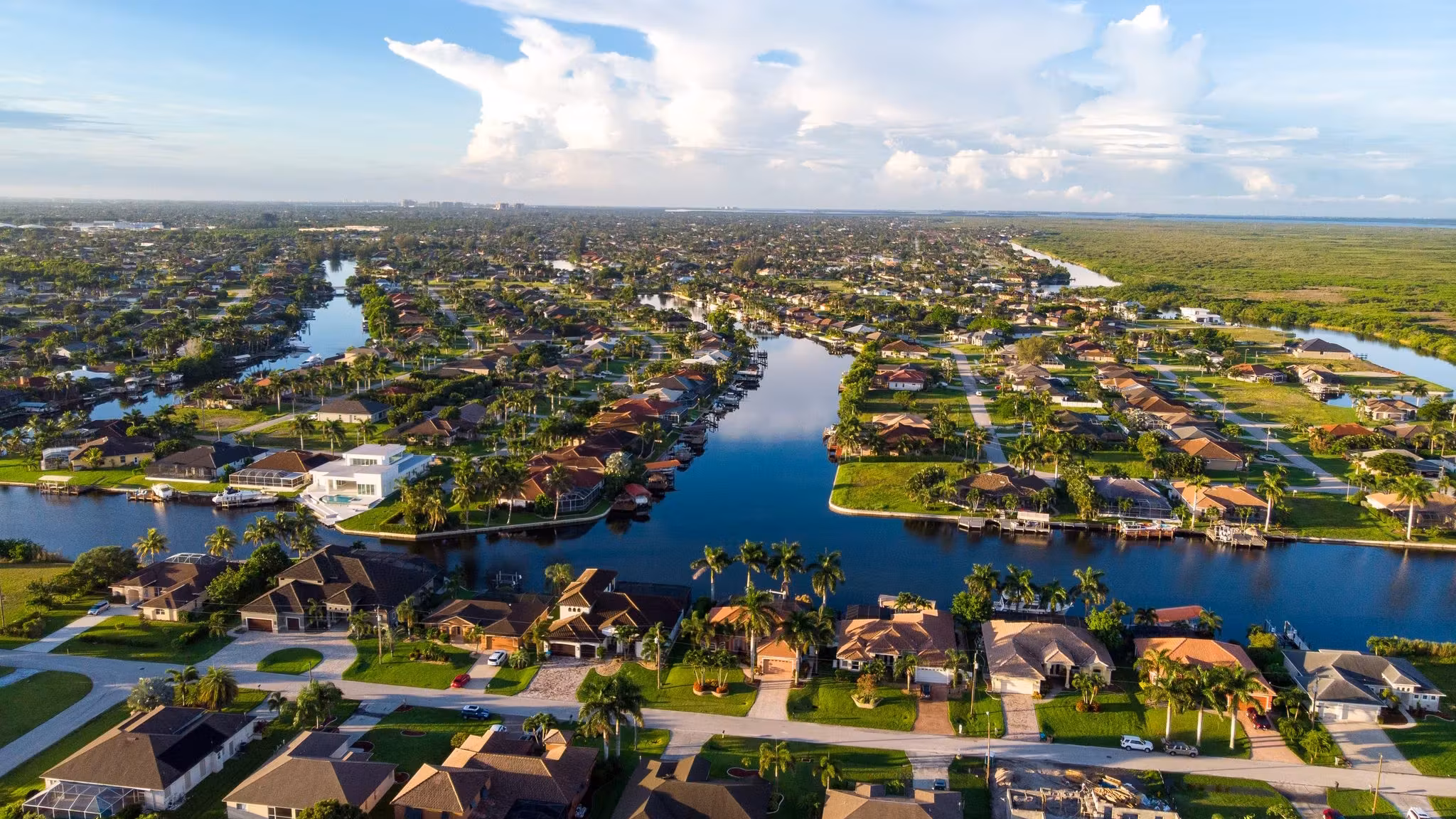 Aerial view of a Florida neighborhood, houses lining canals that run out to the coast