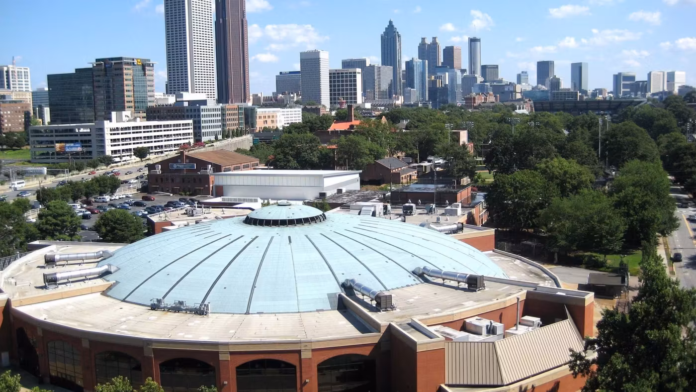A domed arena in Atlanta with the Midtown towers behind it