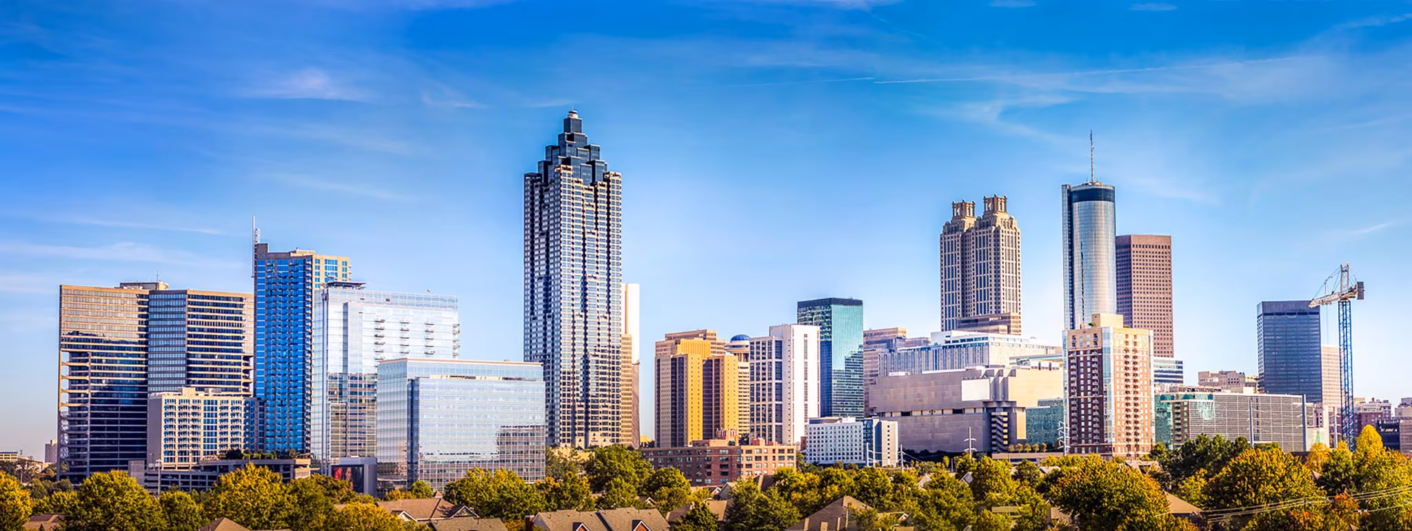 The Atlanta skyline above a belt of trees on a clear day