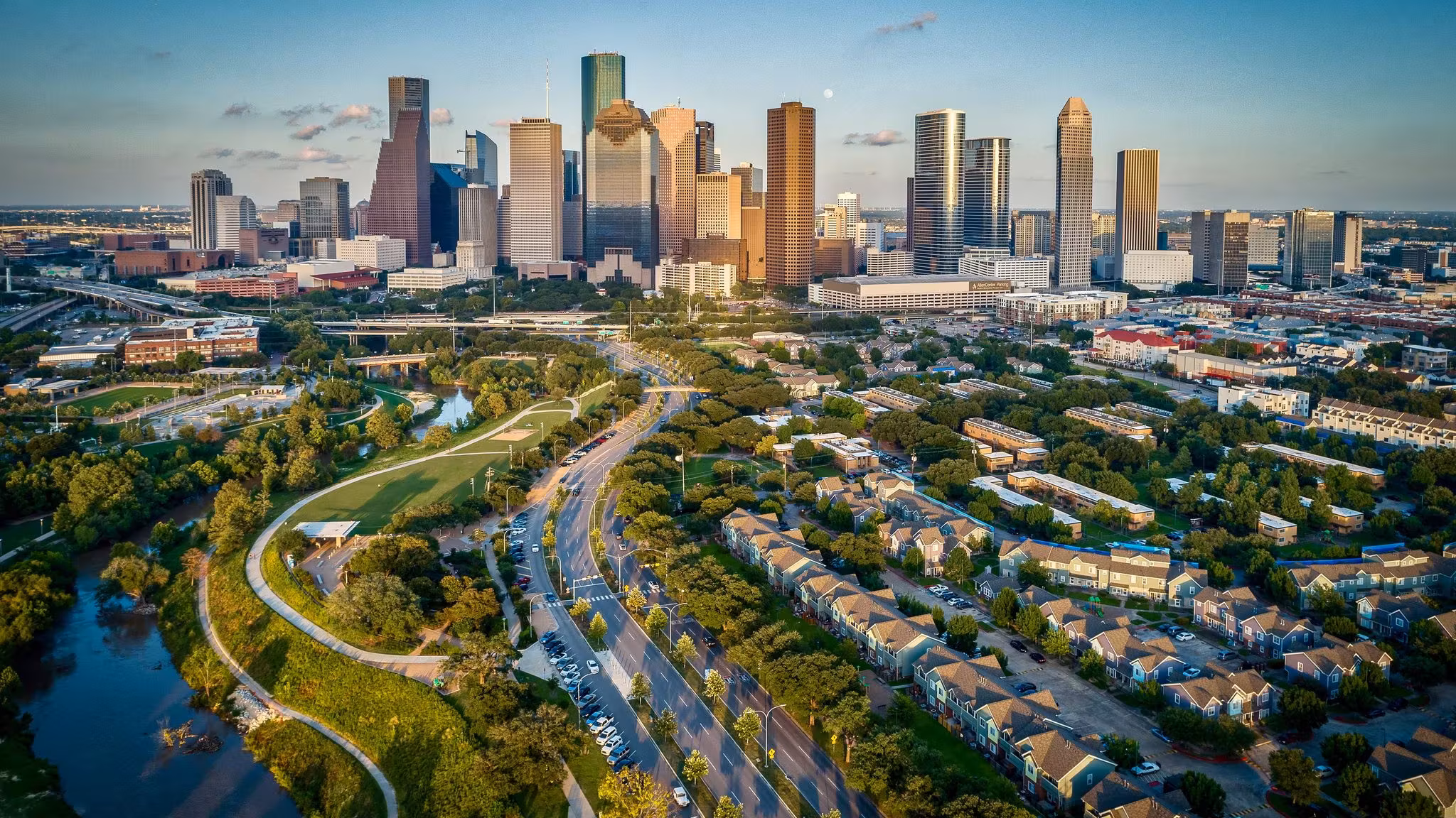 Townhouses along a Houston bayou with the downtown towers beyond