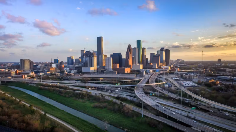 The Houston skyline above a wide freeway interchange
