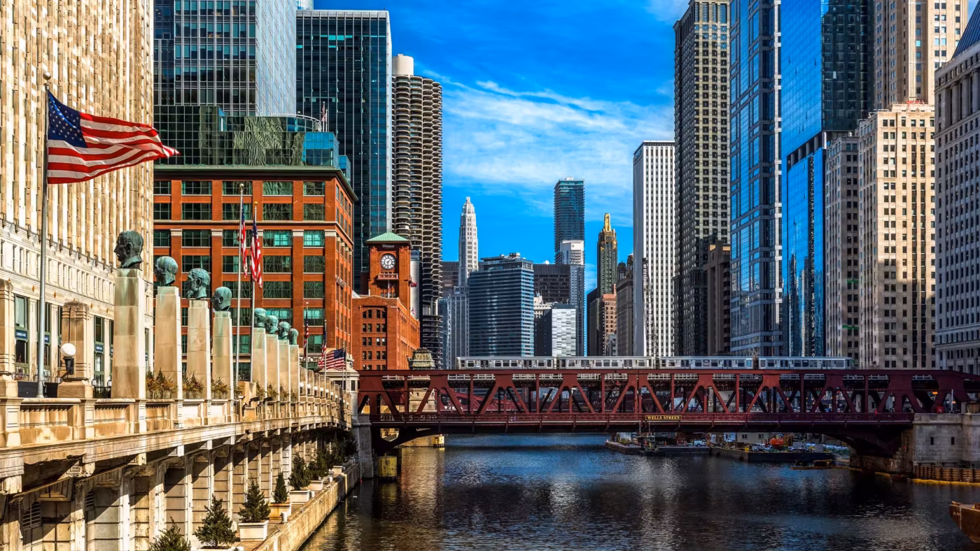 A bascule bridge over the Chicago River with flags flying from a riverside building