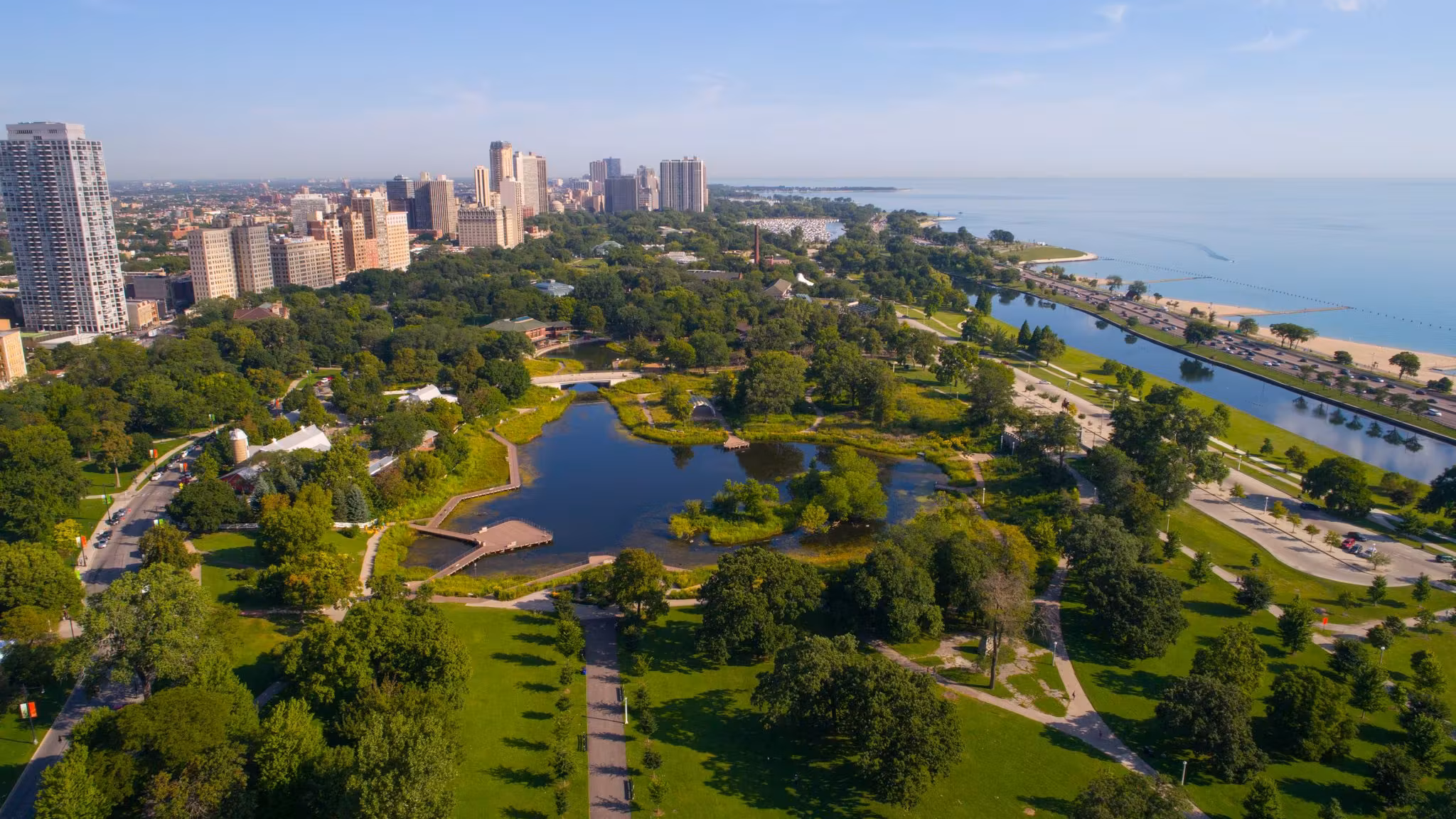A Chicago lakefront park with lagoons and paths, the skyline along the shore